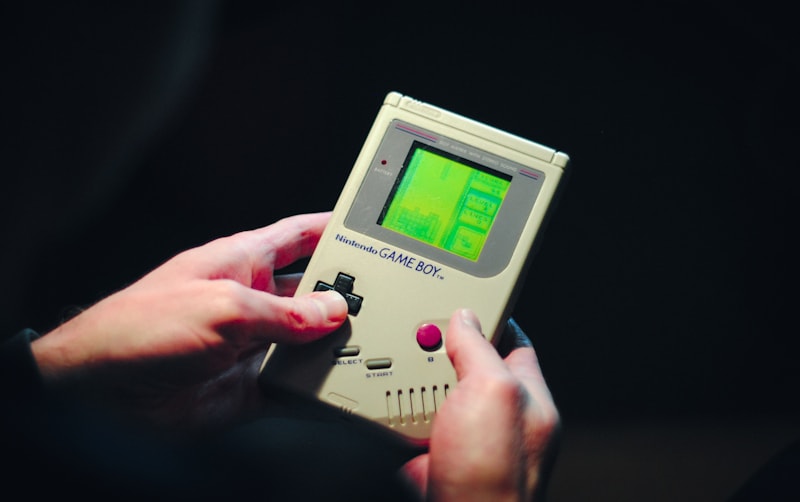 Person holding a gray original Nintendo Game Boy in their hands